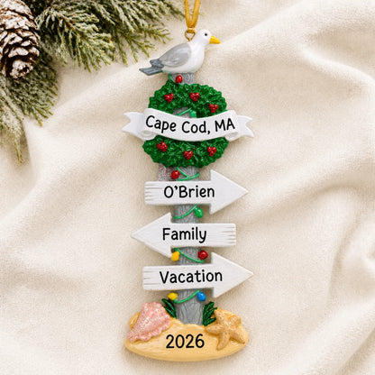 Personalized beach signs christmas ornament laid on a soft white knit blanket