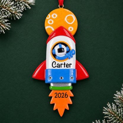 Personalized space rocket christmas ornament on a dark green pine background