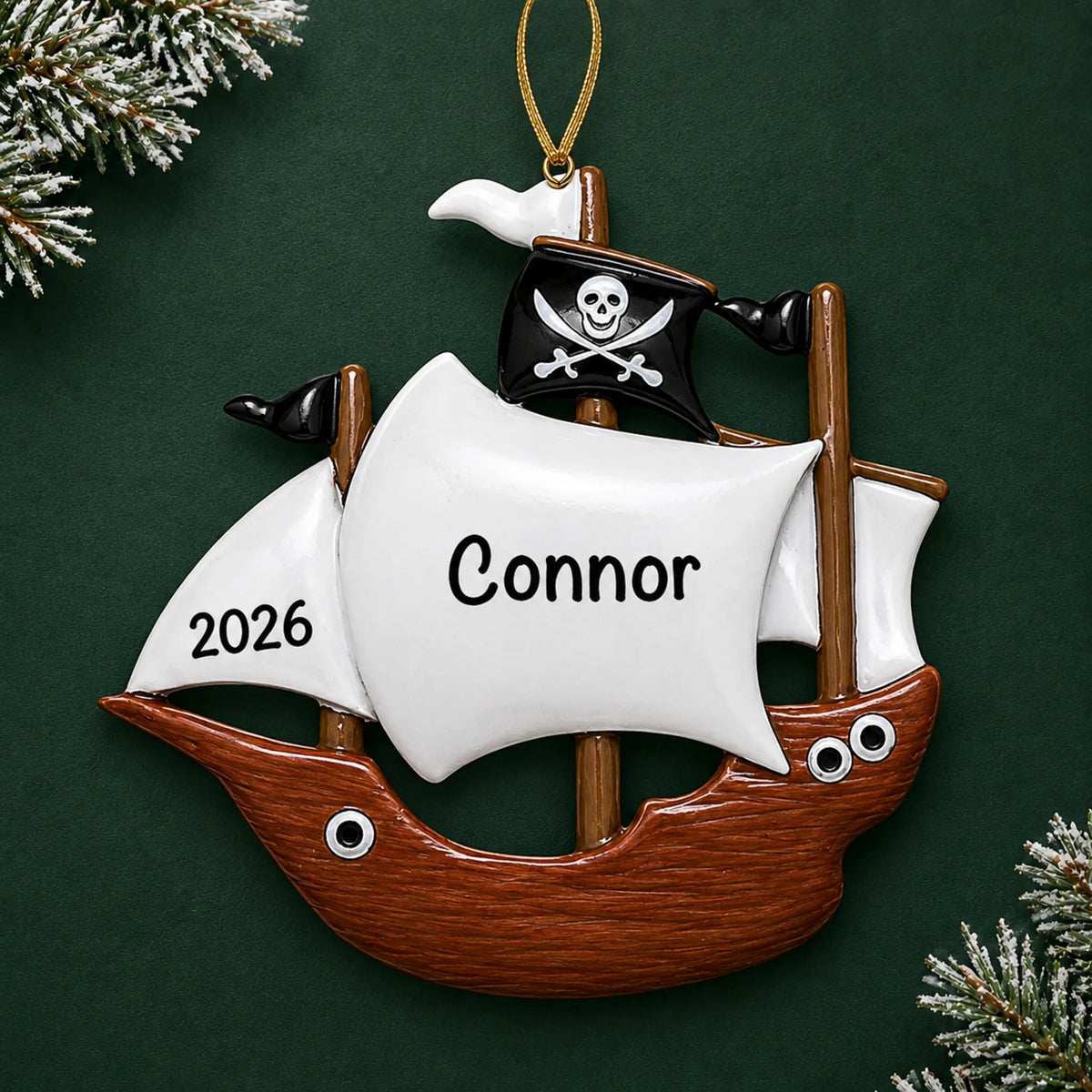 Personalized pirate ship kids christmas ornament on a dark green pine background
