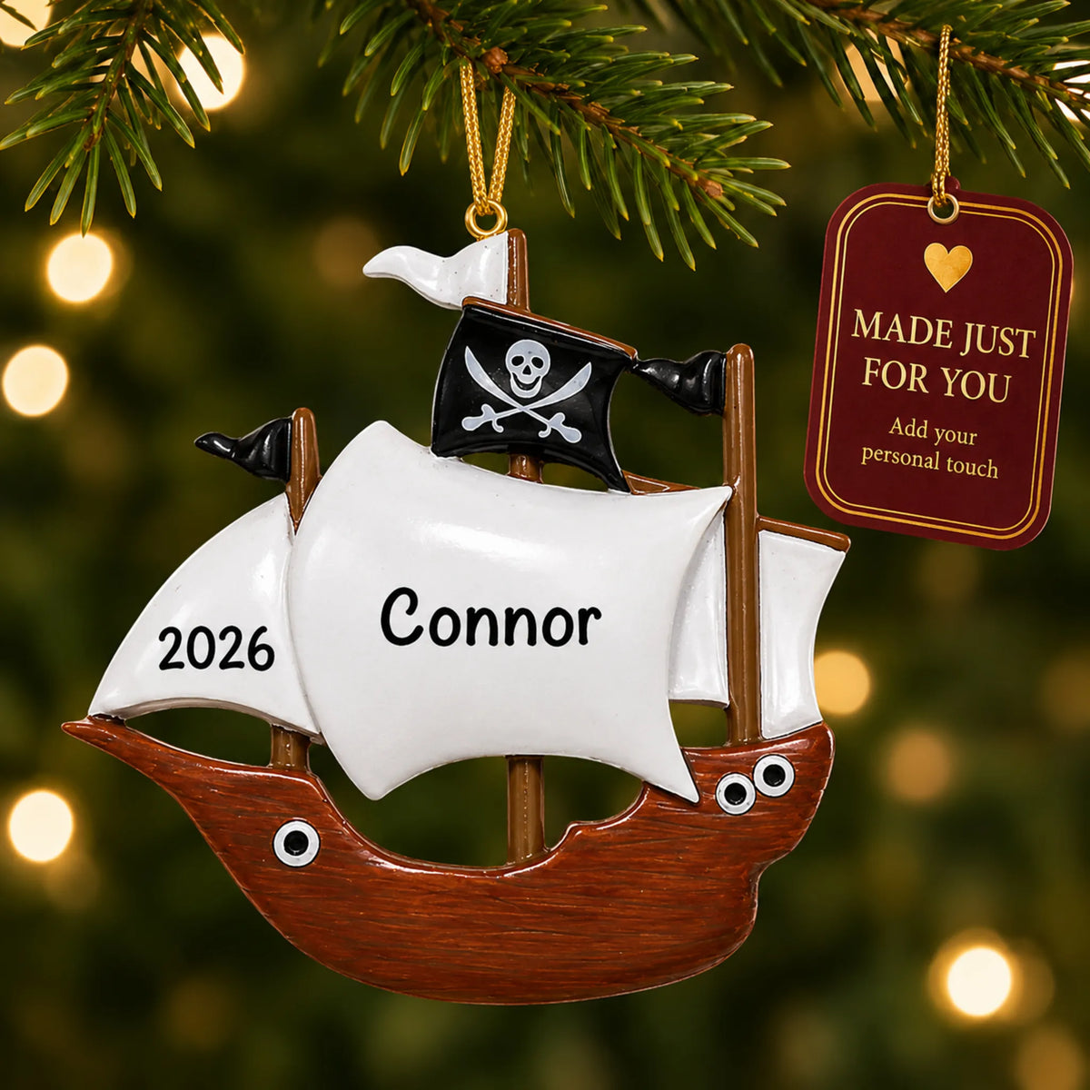 Pirate ship kids christmas ornament hanging on a lit Christmas tree with a Made Just For You gift tag