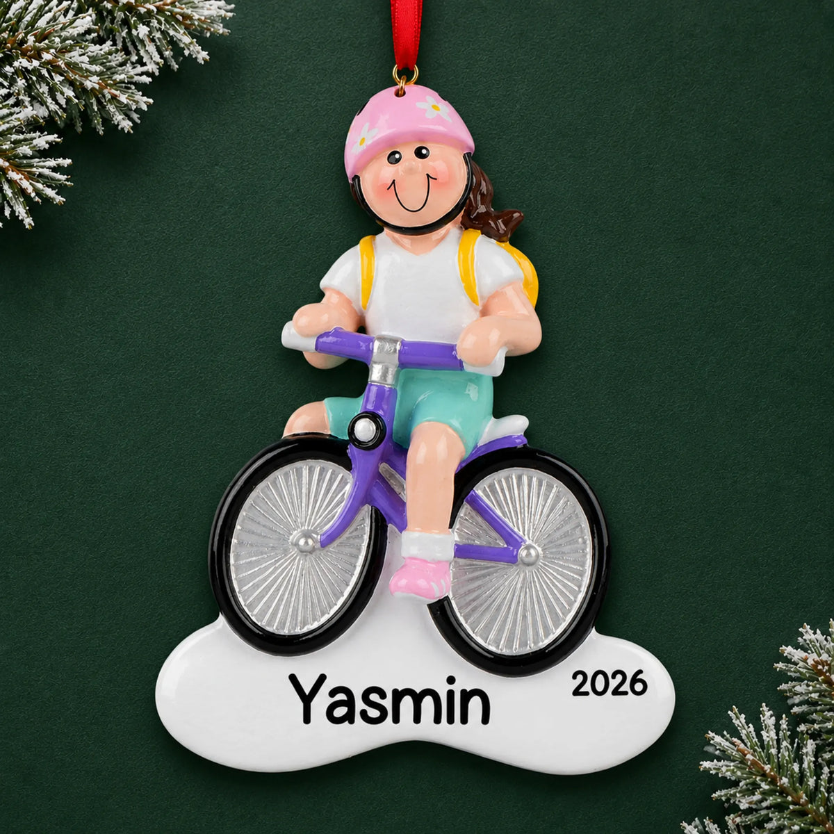 Personalized brunette girl bike christmas ornament on a dark green pine background