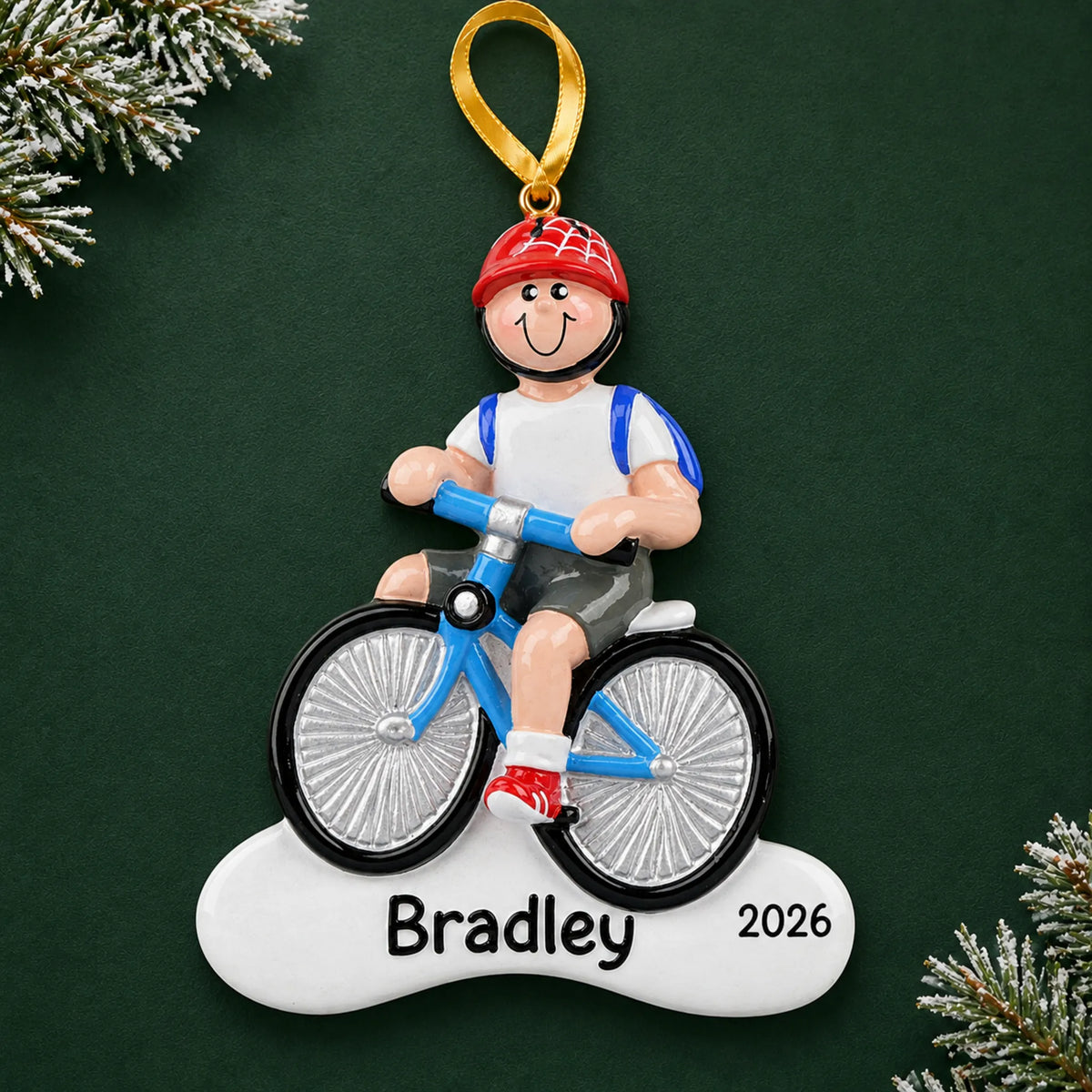 Personalized boy riding a bike christmas ornament on a dark green pine background