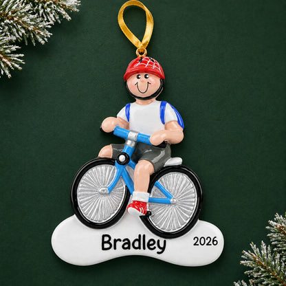 Personalized boy riding a bike christmas ornament on a dark green pine background