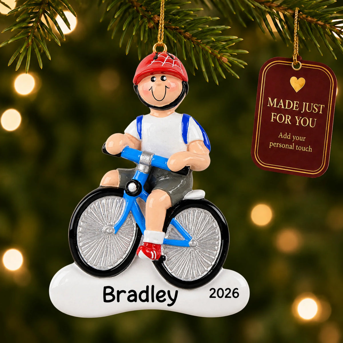 Boy riding a bike christmas ornament hanging on a lit Christmas tree with a Made Just For You gift tag