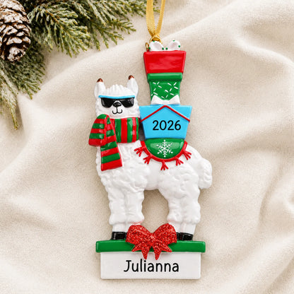 Personalized llama christmas ornament laid on a soft white knit blanket