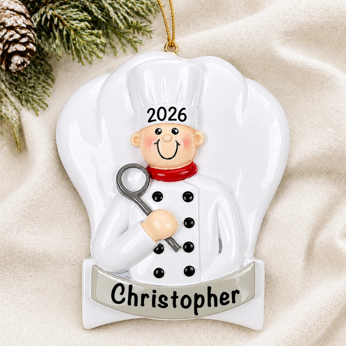 Personalized chef cooking christmas ornament laid on a soft white knit blanket