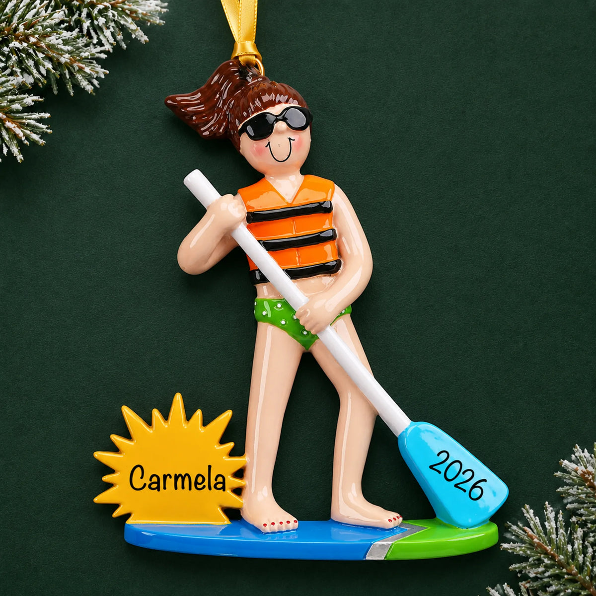 Personalized paddle board girl christmas ornament on a dark green pine background