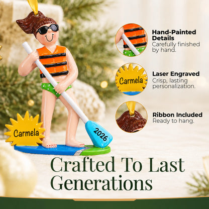 Hand-painted details and laser engraved personalization on the paddle board girl christmas ornament, ribbon included
