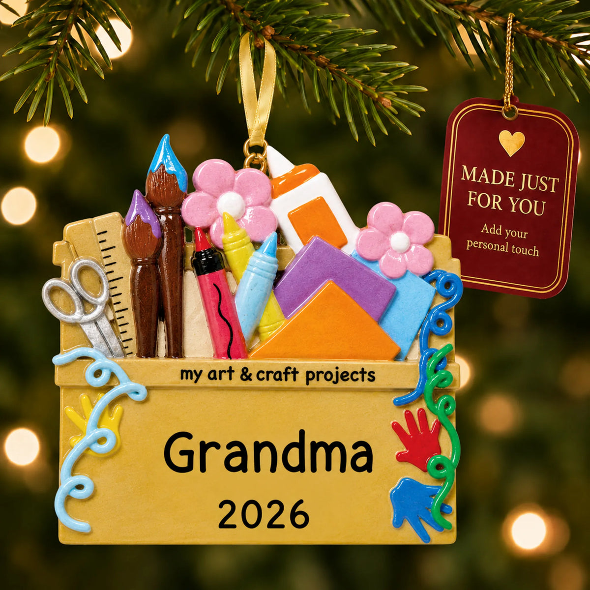 Arts and craft supplies christmas ornament hanging on a lit Christmas tree with a Made Just For You gift tag