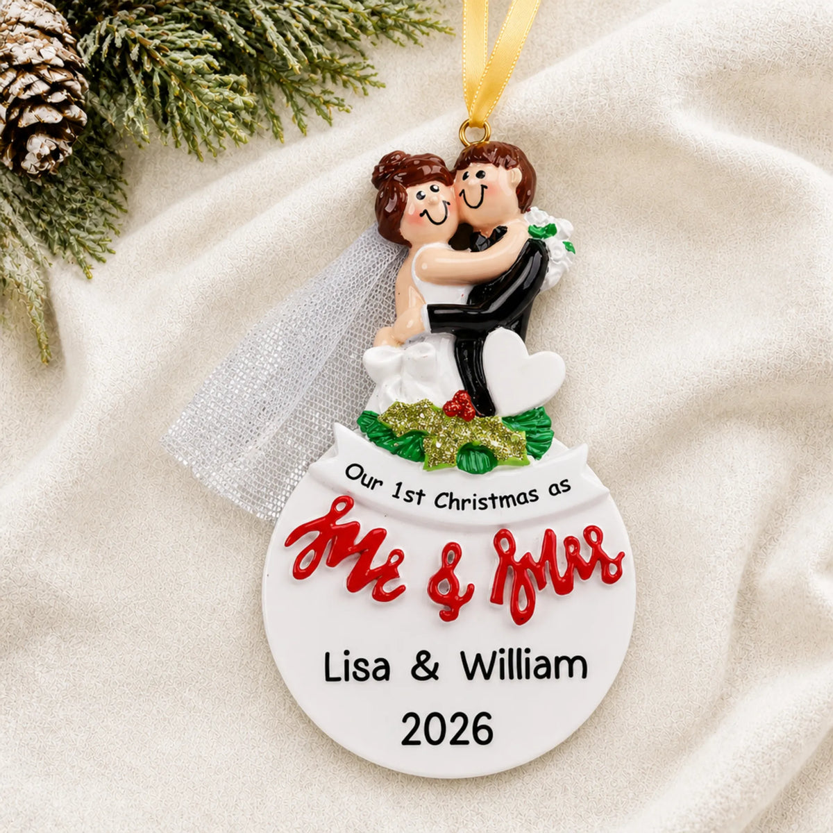 Personalized Mr. & Mrs. bride and groom Christmas ornament on a cream knit blanket beside pine and pinecones