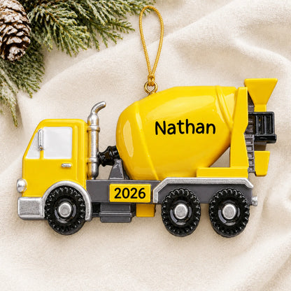 Personalized cement truck christmas ornament laid on a soft white knit blanket