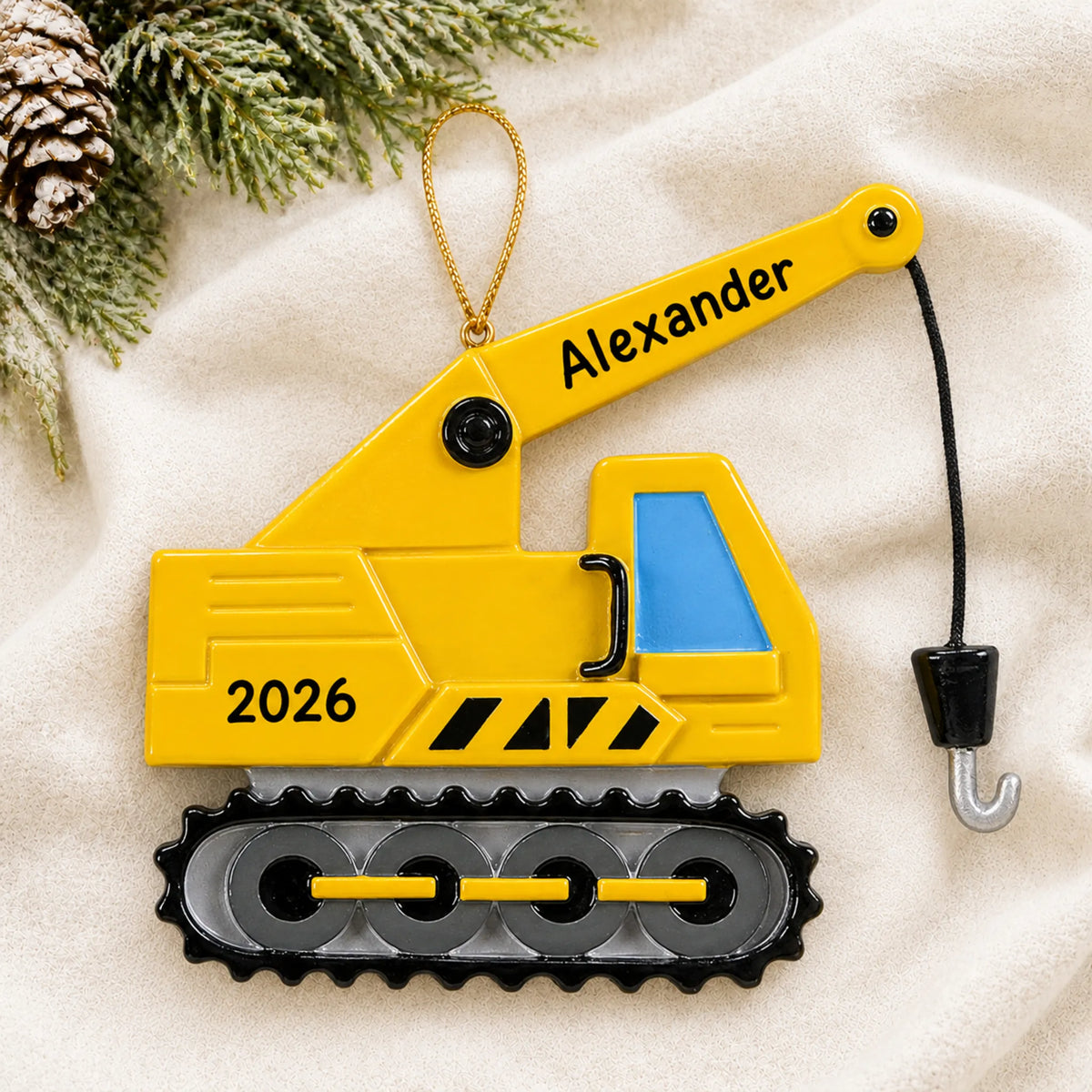 Personalized construction crane christmas ornament laid on a soft white knit blanket