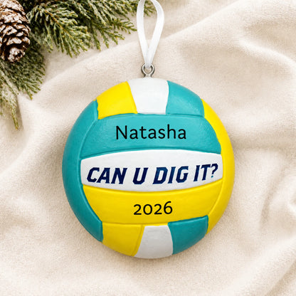 Personalized Can U Dig It volleyball christmas ornament laid on a soft white knit blanket