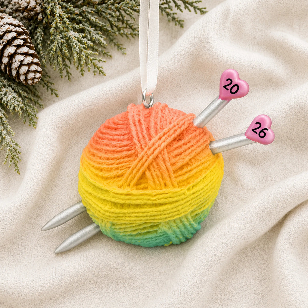 Personalized 3d knitting yarn ball christmas ornament laid on a soft white knit blanket