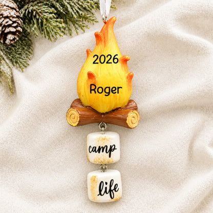 Personalized campfire christmas ornament laid on a soft white knit blanket