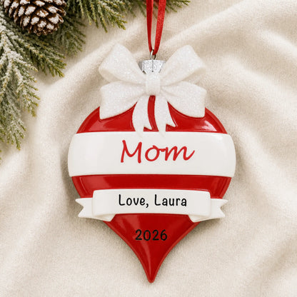 Personalized mom red christmas ornament laid on a soft white knit blanket
