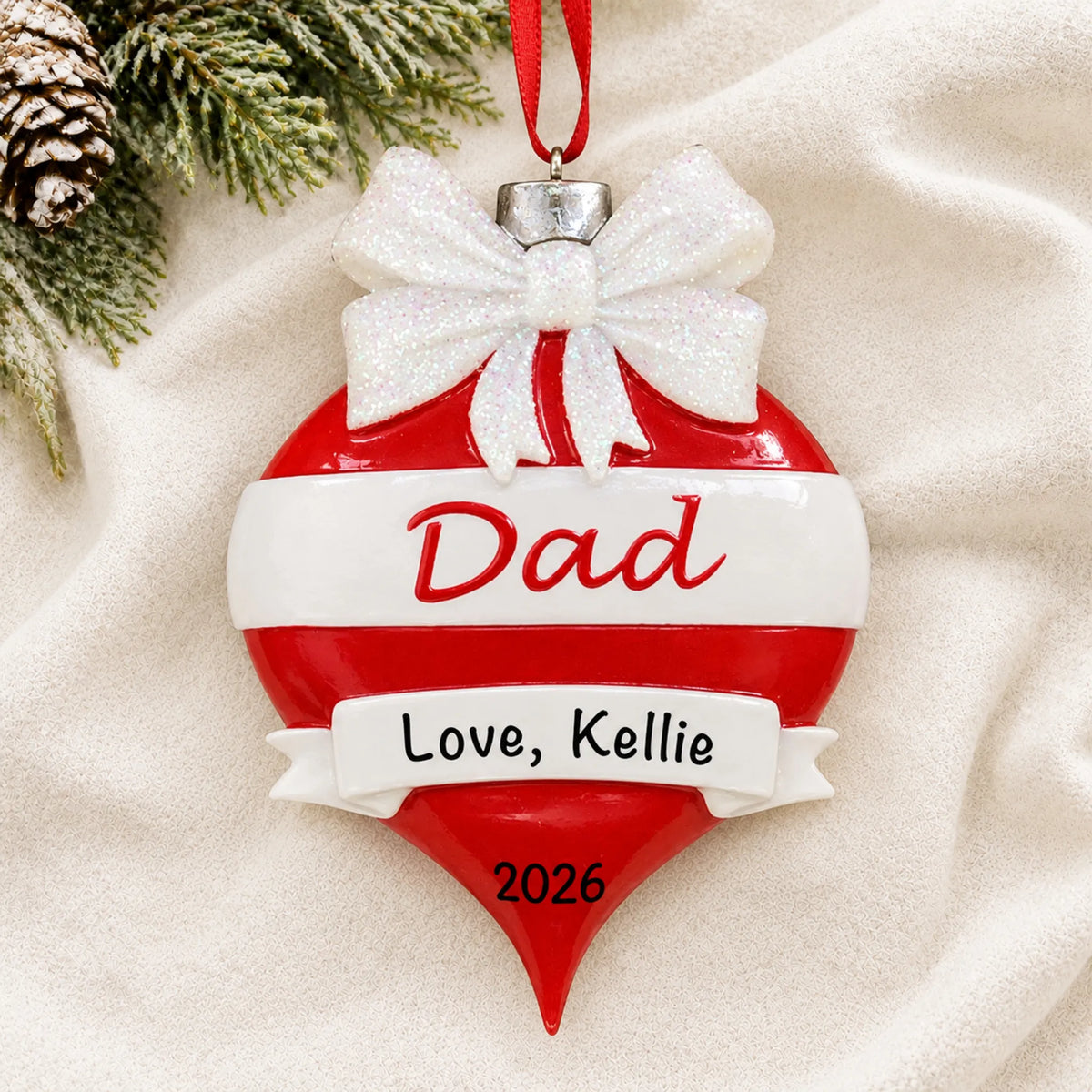 Personalized dad red christmas ornament laid on a soft white knit blanket