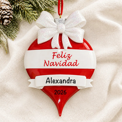 Personalized Feliz Navidad christmas ornament laid on a soft white knit blanket