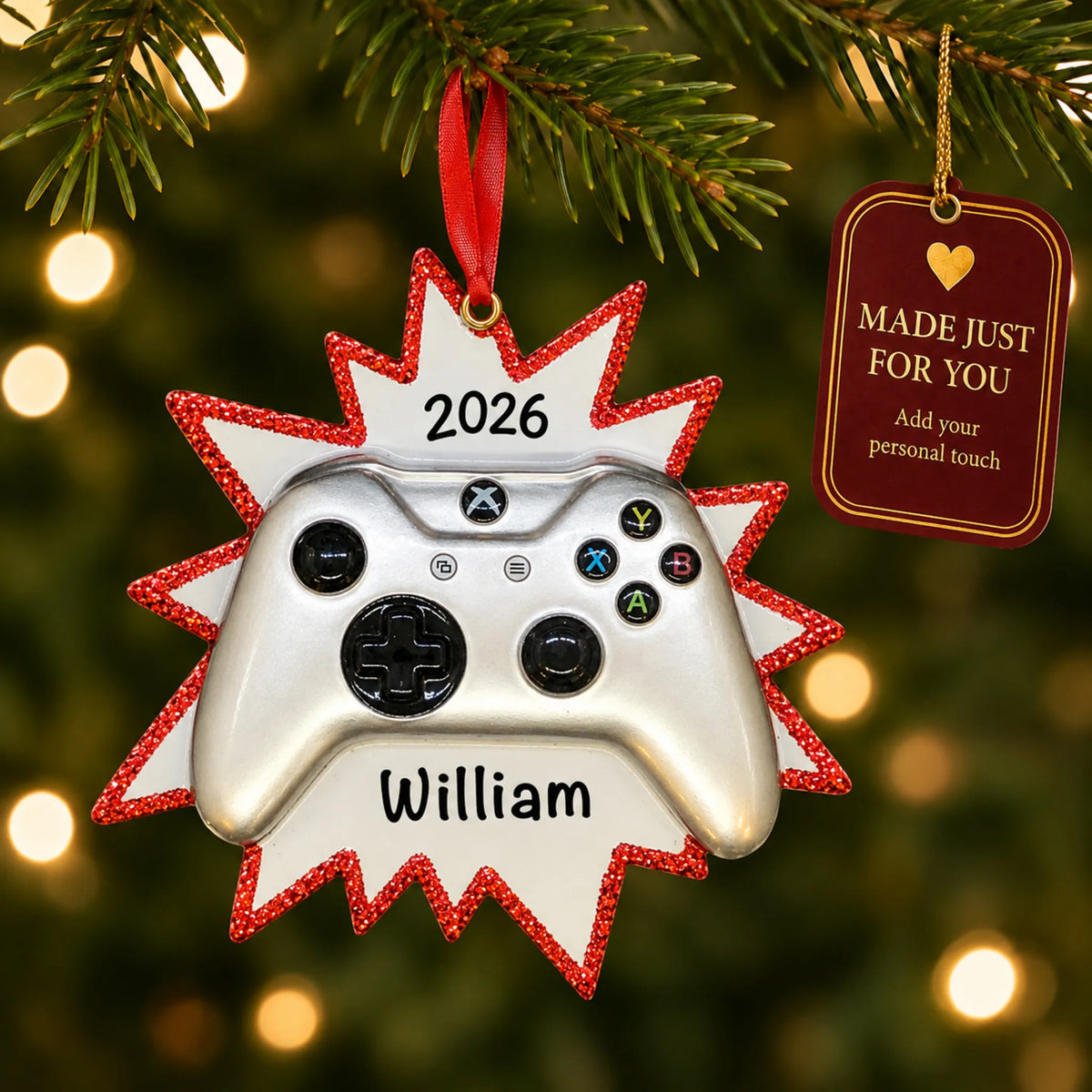 Silver video game controller christmas ornament hanging on a lit Christmas tree with a Made Just For You gift tag
