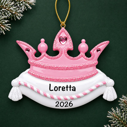 Personalized pink princess crown christmas ornament on a dark green pine background