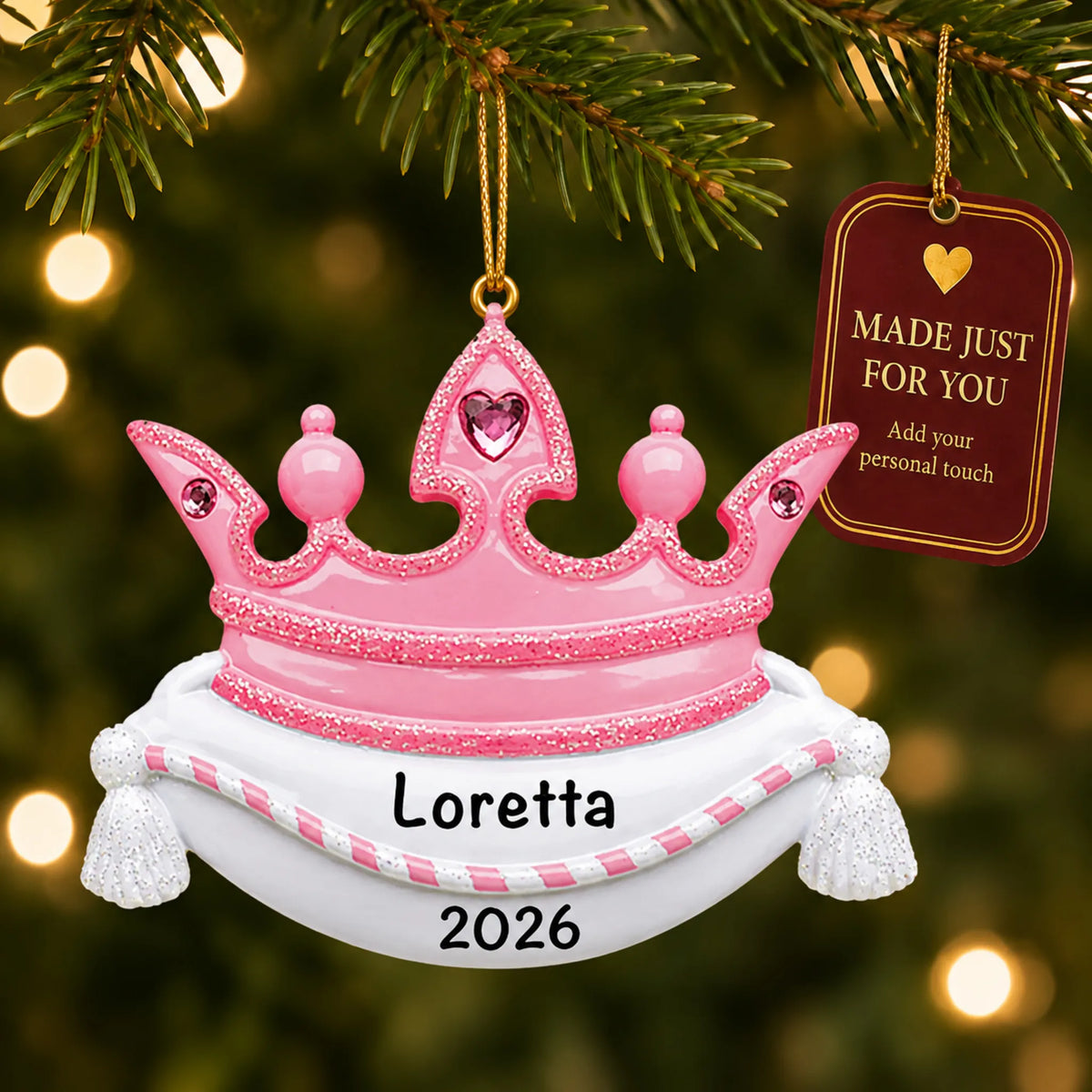 Pink princess crown christmas ornament hanging on a lit Christmas tree with a Made Just For You gift tag