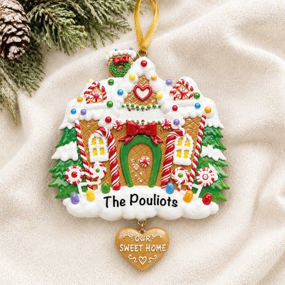 Personalized Gingerbread House christmas ornament laid on a soft white knit blanket