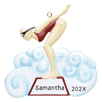 Personalized Christmas ornament featuring a female swimmer in a red swimsuit, cap, and goggles, poised on a starting block above a blue water cloud, ready for custom engraving.