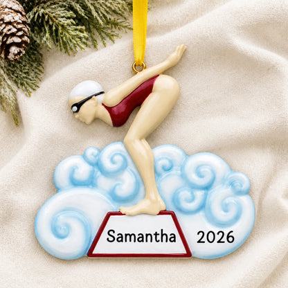 Personalized girl swimmer christmas ornament laid on a soft white knit blanket