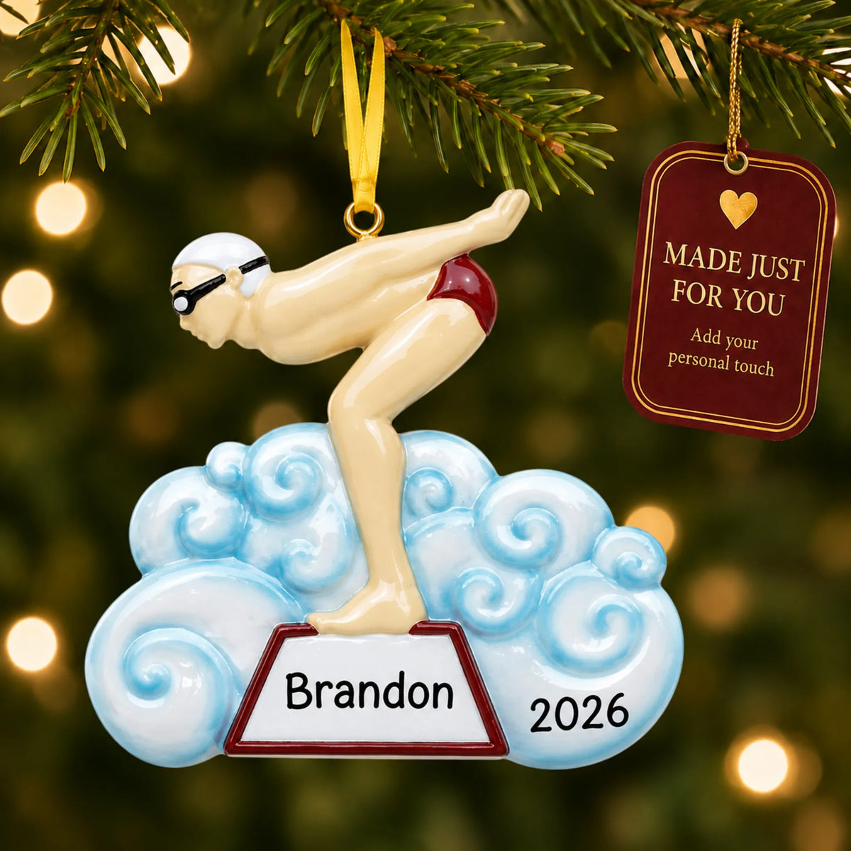 Boy swimmer christmas ornament hanging on a lit Christmas tree with a Made Just For You gift tag