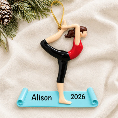 Personalized yoga christmas ornament laid on a soft white knit blanket