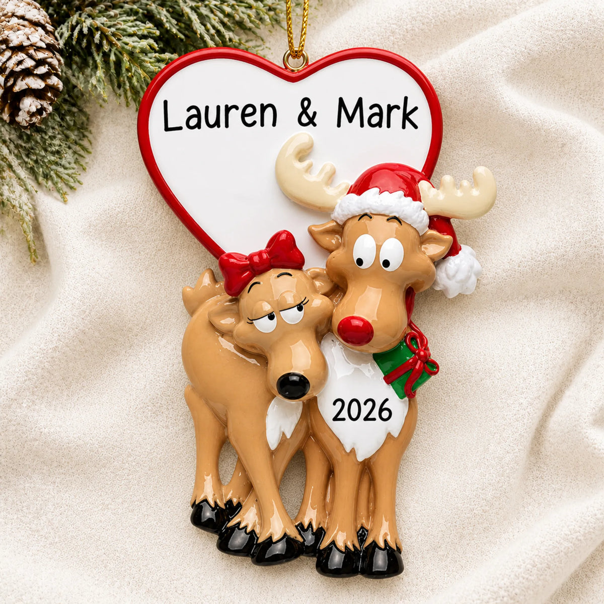 Personalized reindeer couple christmas ornament laid on a soft white knit blanket