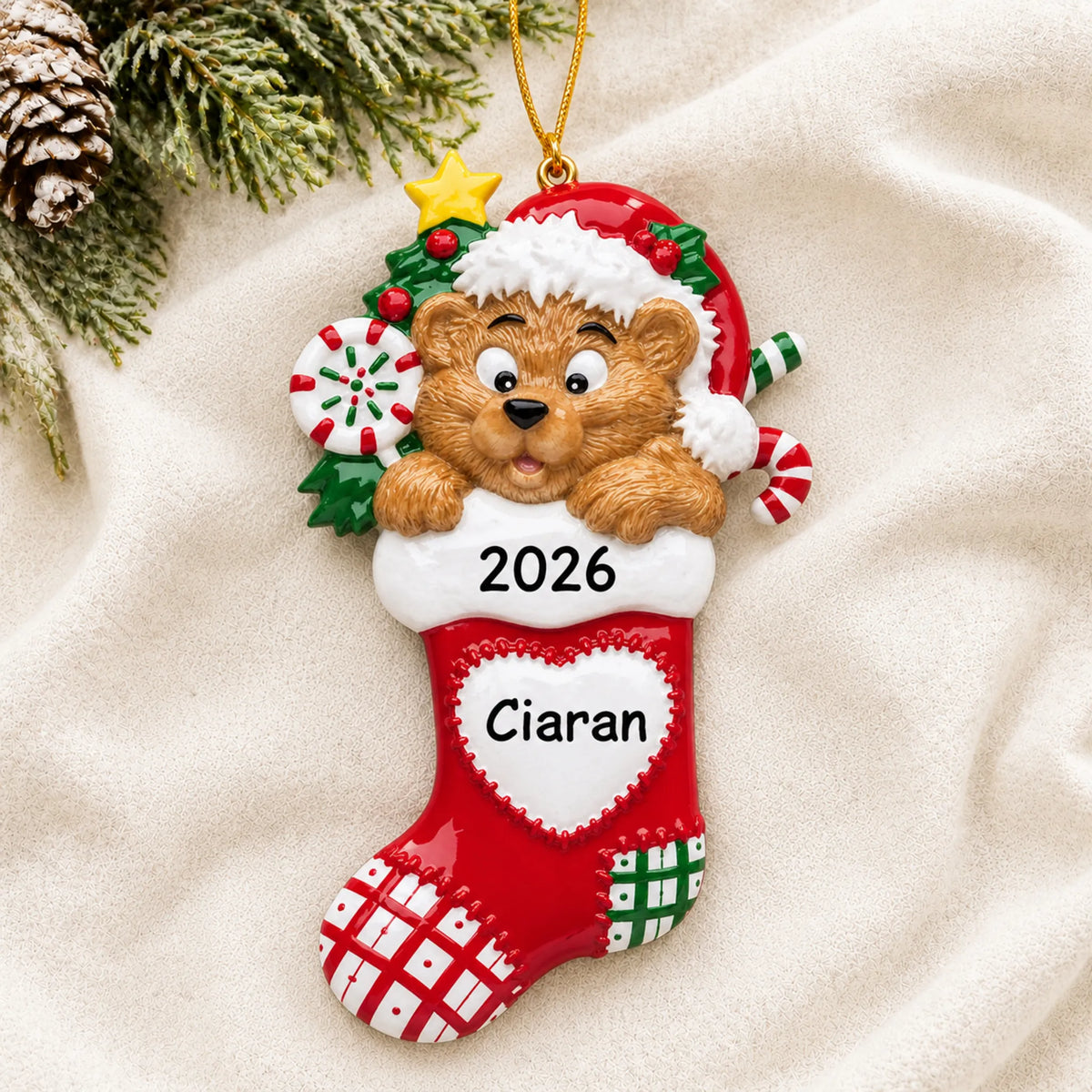 Personalized Bear Stocking christmas ornament laid on a soft white knit blanket