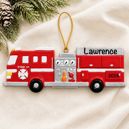 Personalized fire engine christmas ornament laid on a soft white knit blanket