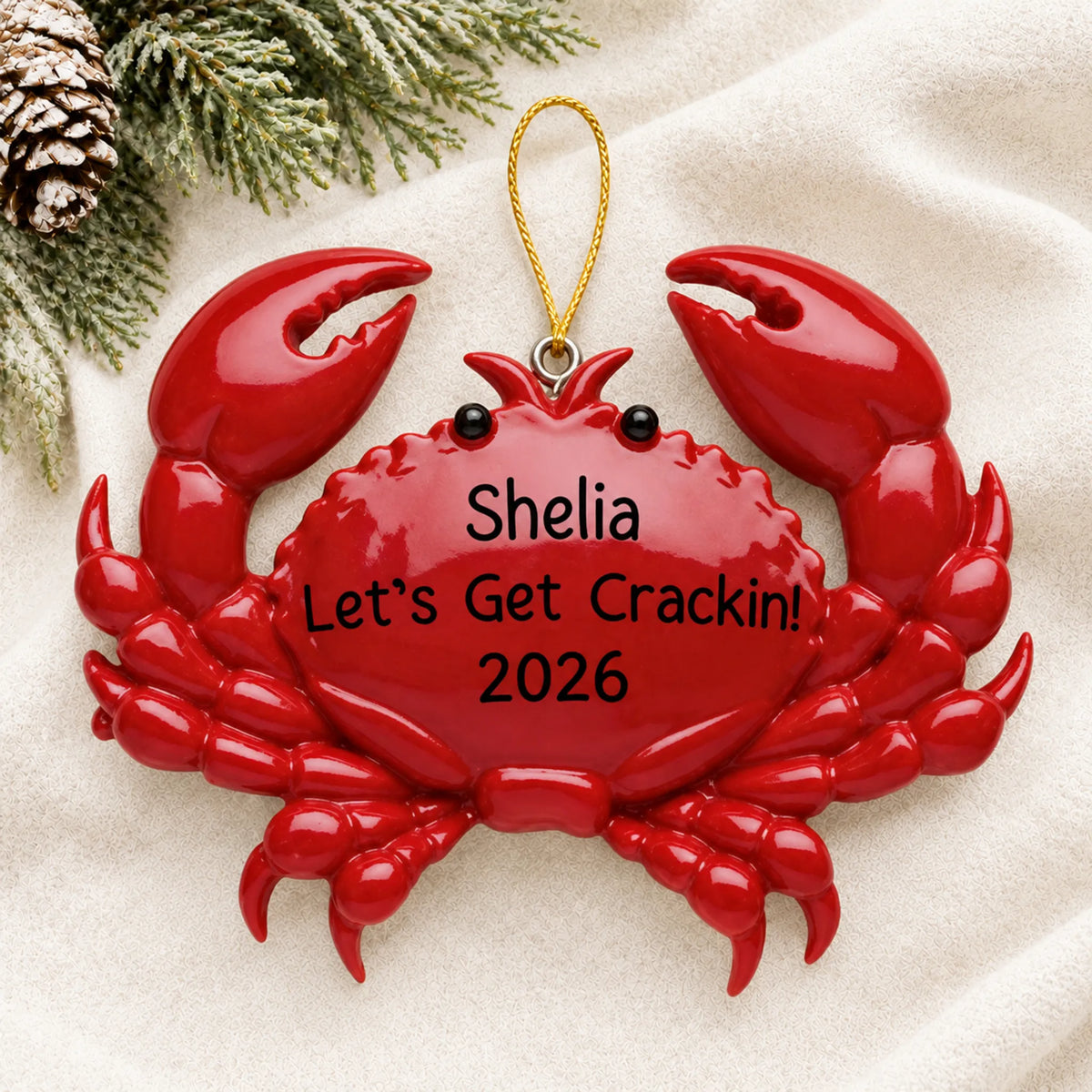 Personalized crab christmas ornament laid on a soft white knit blanket