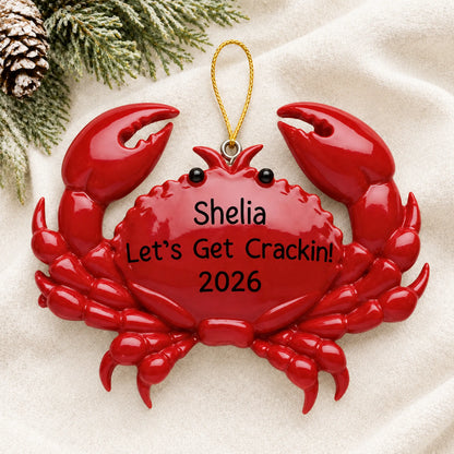 Personalized crab christmas ornament laid on a soft white knit blanket