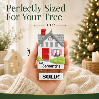 Size guide: the personalized Real Estate Sold House christmas ornament is 2.25 in wide by 4.25 in tall, shown in hand