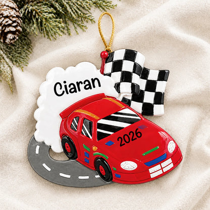 Personalized race car christmas ornament laid on a soft white knit blanket