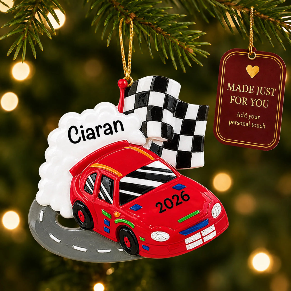 Race car christmas ornament hanging on a lit Christmas tree with a Made Just For You gift tag