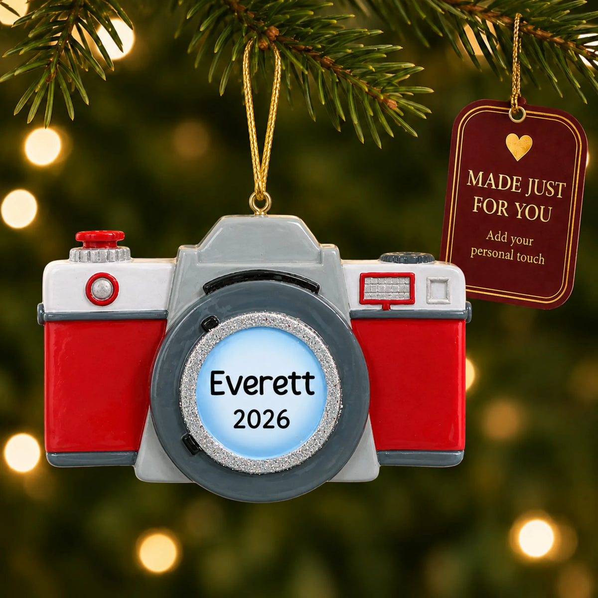 Camera christmas ornament hanging on a lit Christmas tree with a Made Just For You gift tag