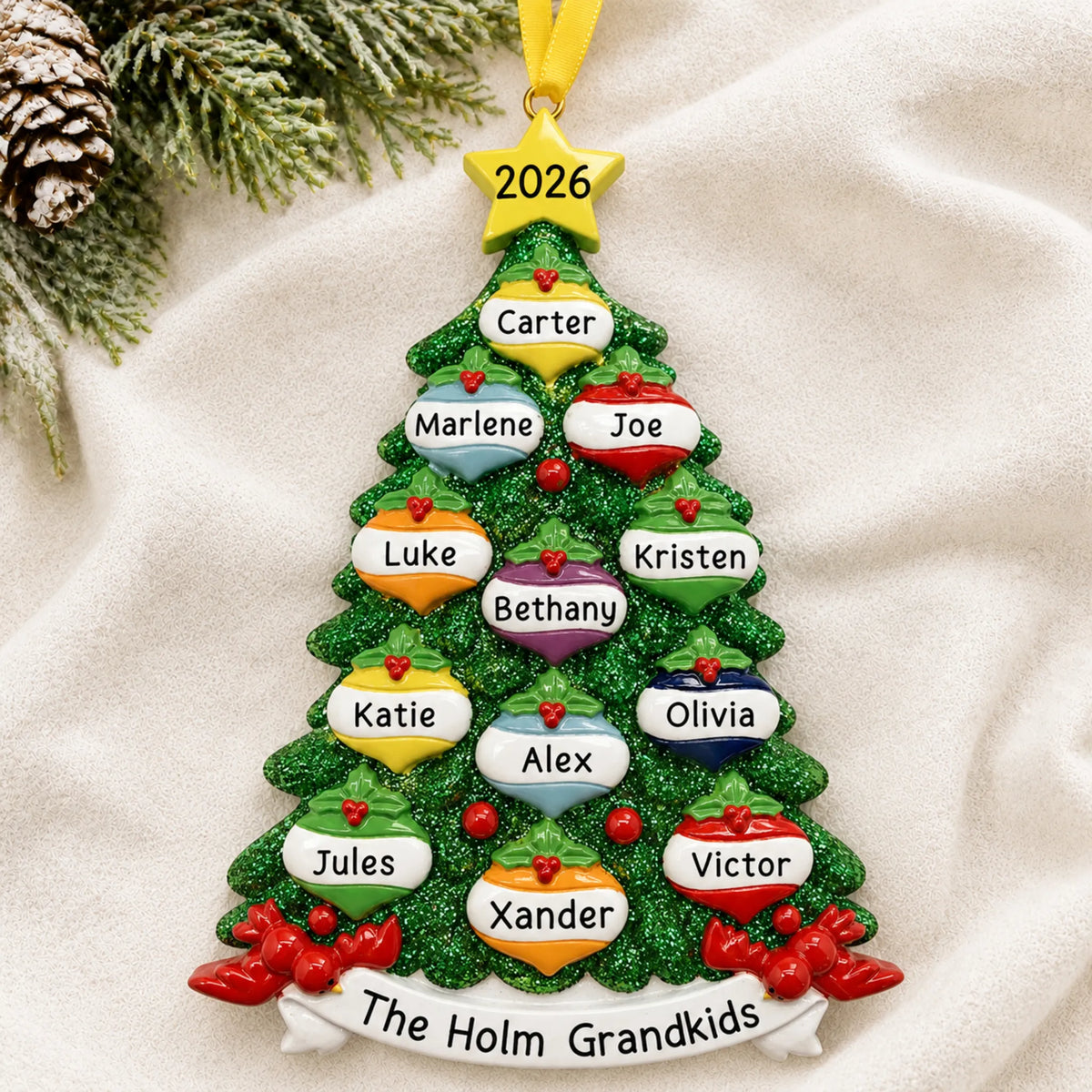 Personalized green glitter tree family of 12 christmas ornament laid on a soft white knit blanket
