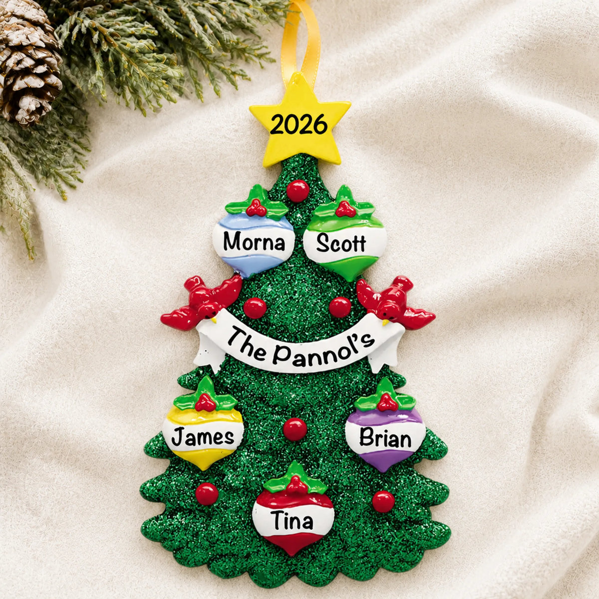 Personalized green glitter tree family of 5 christmas ornament laid on a soft white knit blanket