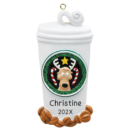 Personalized Christmas ornament shaped like a large white coffee cup with a lid, decorated with a festive reindeer logo and coffee beans, ready for custom name engraving.