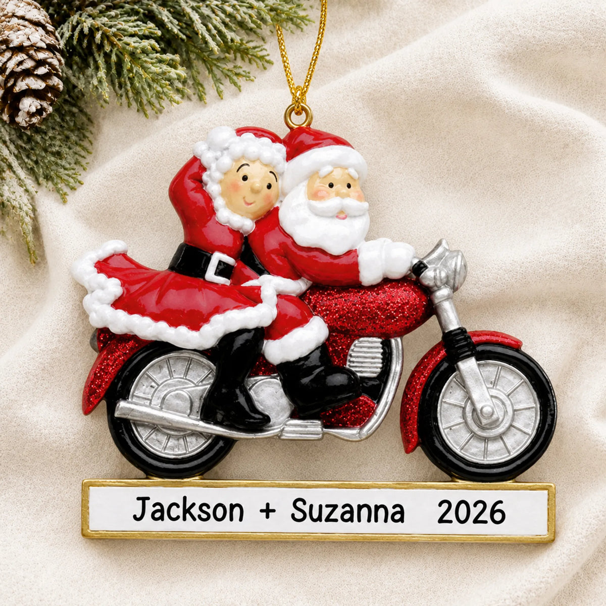 Personalized santa couple motorcycle christmas ornament laid on a soft white knit blanket