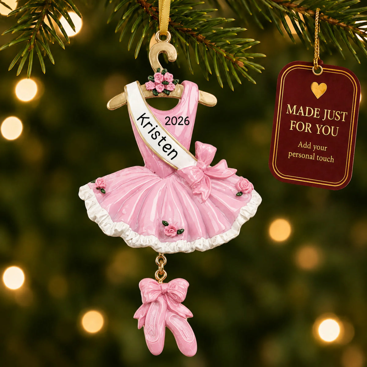 Pink ballerina dress christmas ornament hanging on a lit Christmas tree with a Made Just For You gift tag