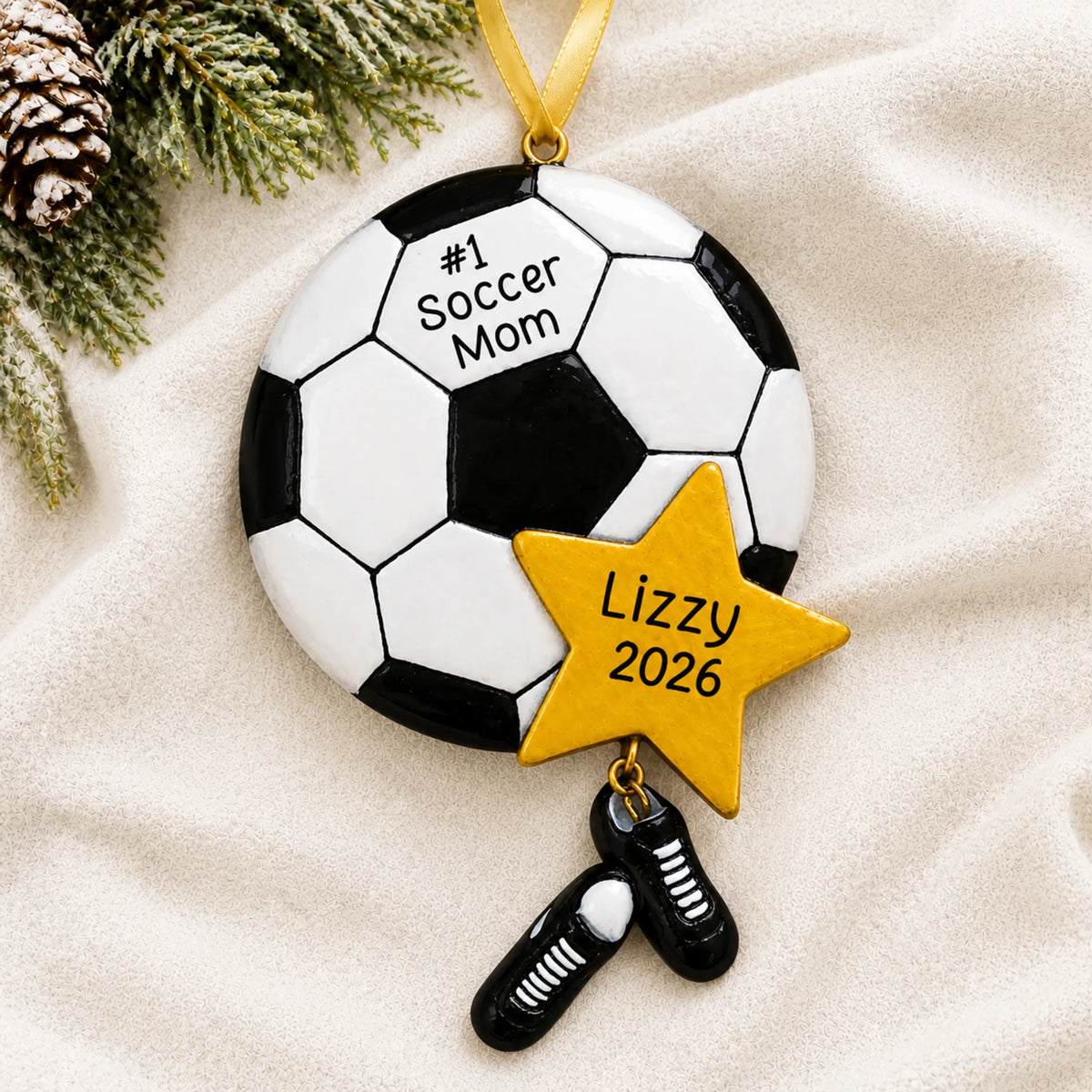 Personalized soccer mom christmas ornament laid on a soft white knit blanket