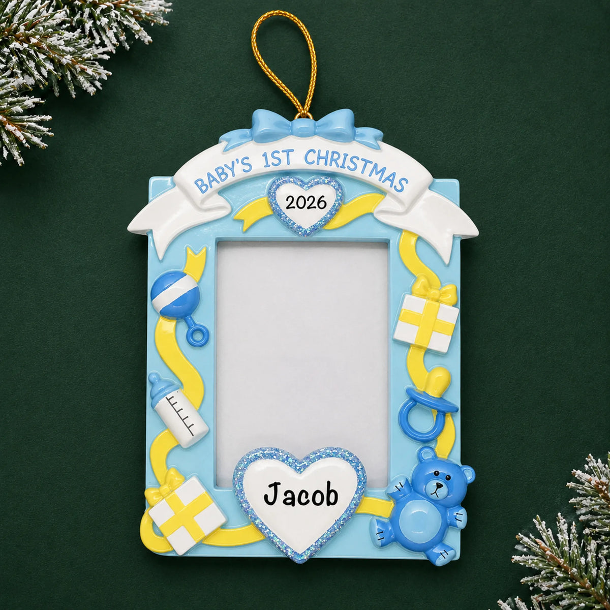 Personalized blue baby's 1st christmas photo frame ornament on a dark green pine background