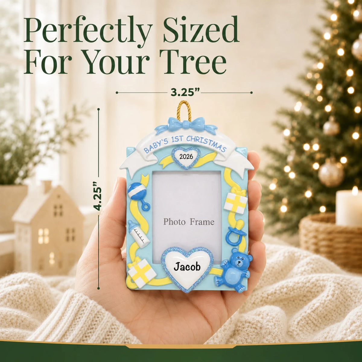 Size guide: the personalized blue baby's 1st christmas photo frame ornament is 3.25 in wide by 4.25 in tall, shown in hand