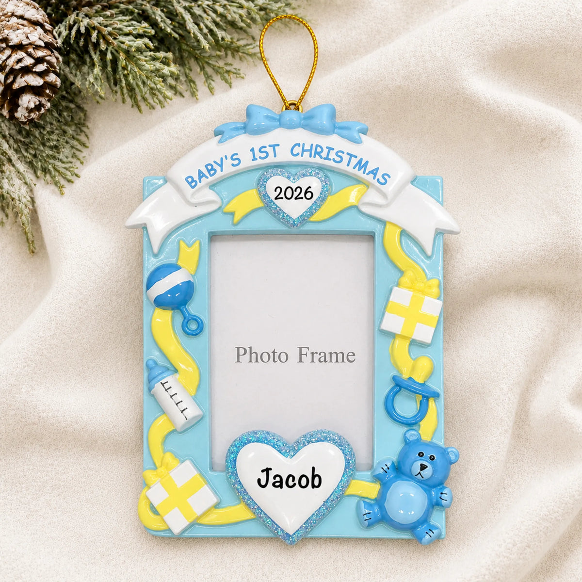 Personalized blue baby's 1st christmas photo frame ornament laid on a soft white knit blanket