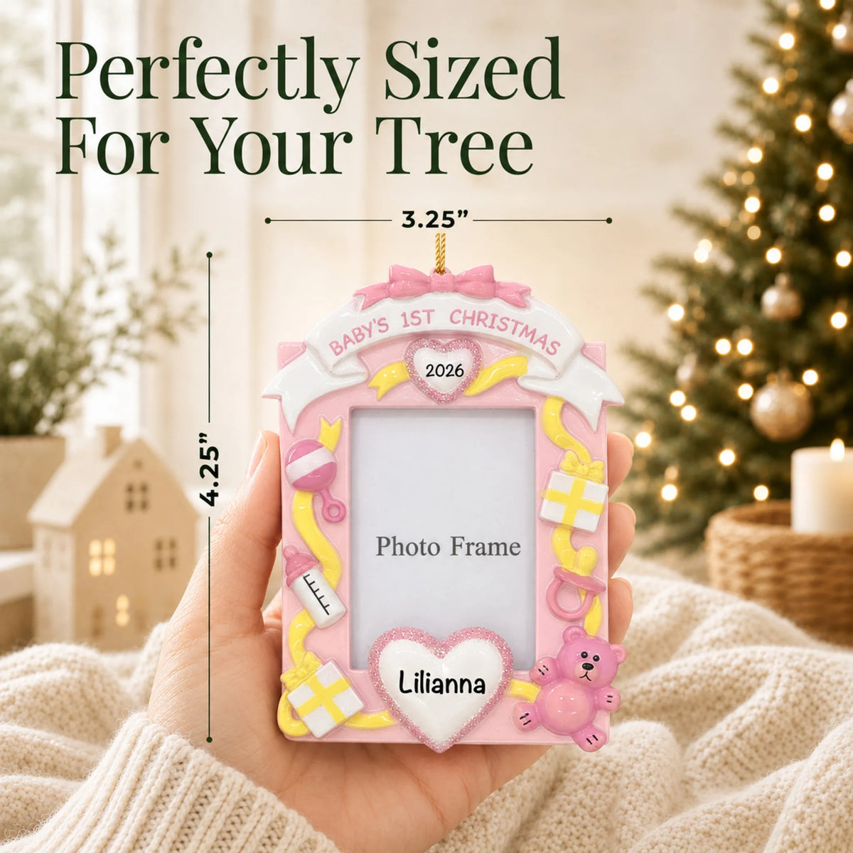 Size guide: the personalized pink baby's 1st christmas photo frame ornament is 3.25 in wide by 4.25 in tall, shown in hand