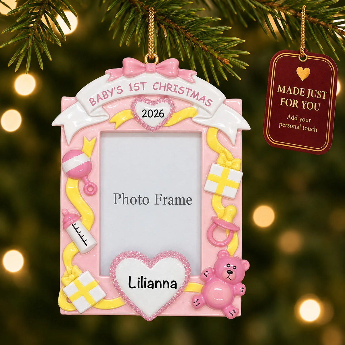 Pink baby's 1st christmas photo frame ornament hanging on a lit Christmas tree with a Made Just For You gift tag